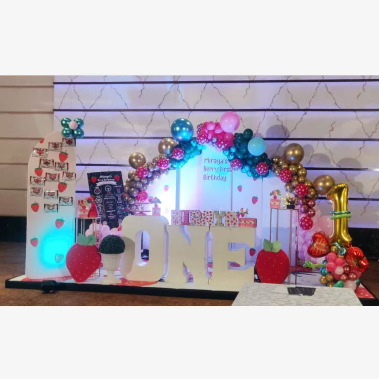 Book Berry First Birthday Decor with strawberry-themed balloon arch, stage setup and personalised birthday backdrop