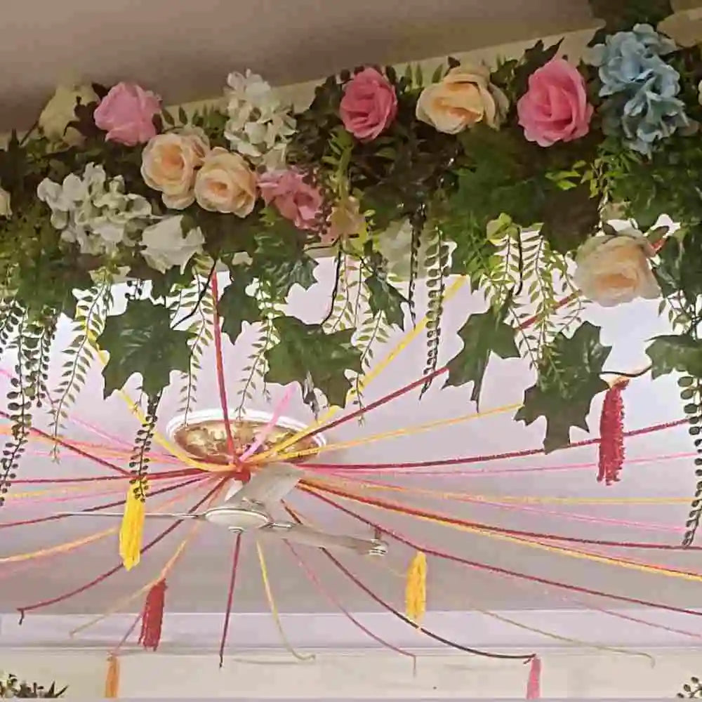 Book Wedding Floral Decor at Home with hanging flowers, green foliage and colourful ceiling drapes
